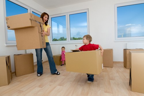 Flat removals team handling furniture and fragile items in a Kew residential building
