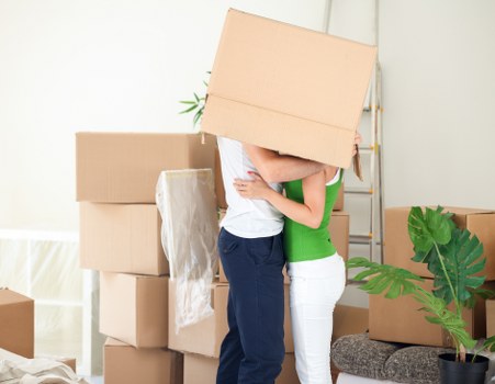 Movers carrying furniture through a residential property during a same day removal