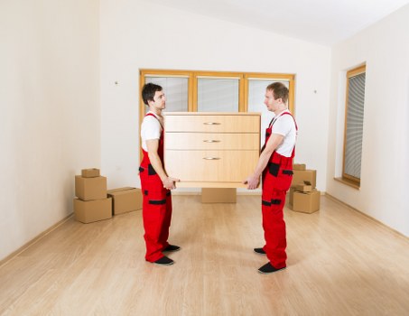 Mover wearing PPE and carrying furniture safely