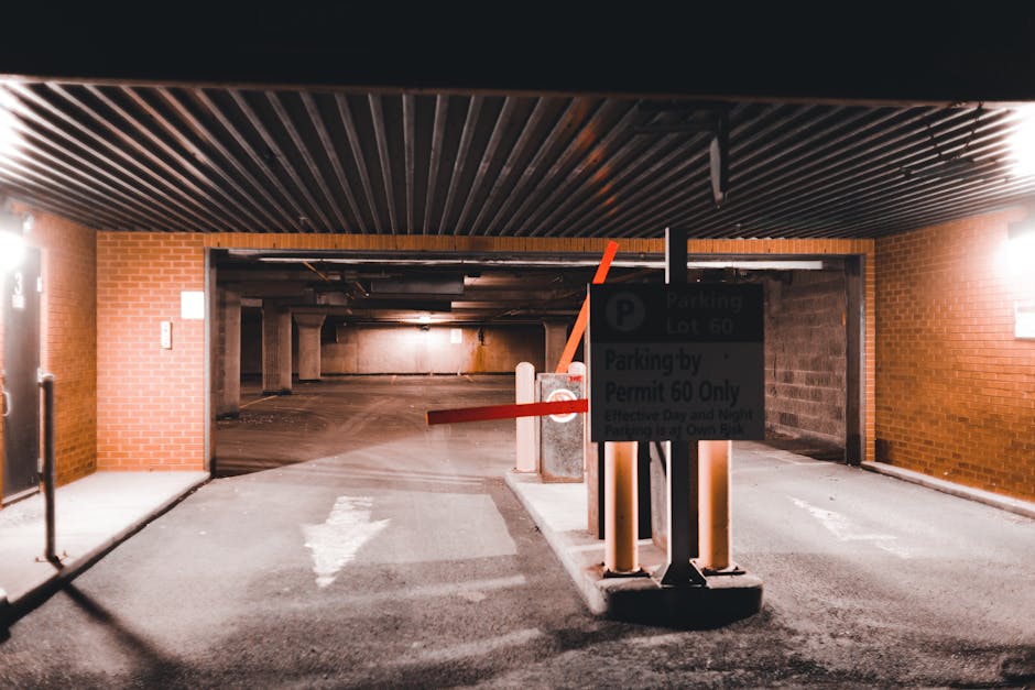 Close-up of a traffic signpost in an urban setting showing two parking regulation signs attached to a metal pole. The top sign indicates no parking except by permit from 7 am to 6 pm, Monday to Friday